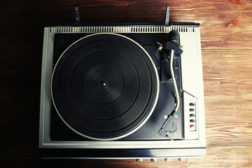 Vintage turntable vinyl record player on wooden background
