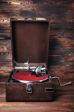 Vintage turntable vinyl record player on wooden background