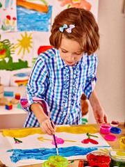 Child painting at easel.