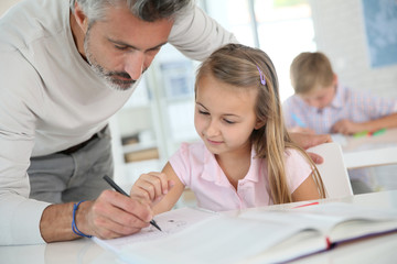 Obraz premium Teacher with schoolgirl in class