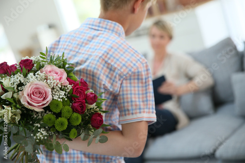 Son hiding bouquet to surprise mommy on mother's day