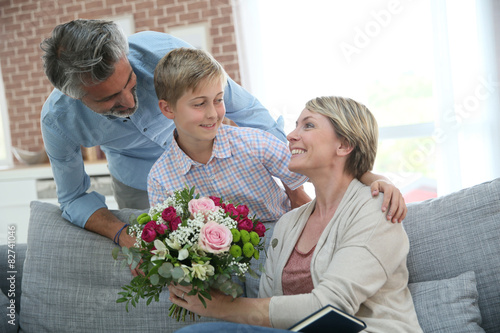 Young boy giving flowers to mommy for mother's day