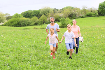 Fototapeta premium Family of four running in countryside
