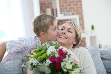 Young boy giving flowers to mommy for mother's day