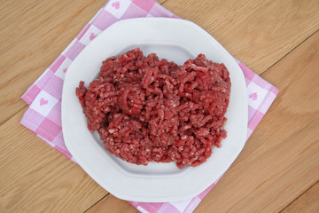 carne macinata cruda su piatto su tavolo di legno