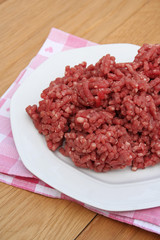 carne macinata cruda su piatto su tavolo di legno