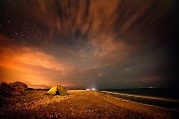 Fototapeta na wymiar touristic tent on the beach by night