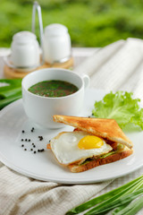 Sandwich with a fried egg and mug of soup
