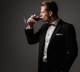 Confident sharp dressed man with glass of wine