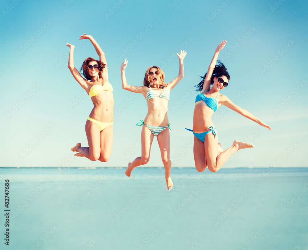 Wall mural girls jumping on the beach