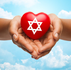 close up of hands holding heart with jewish star