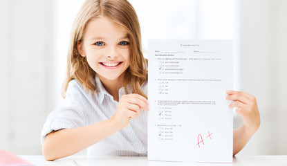 girl with test and A grade at school - obrazy, fototapety, plakaty
