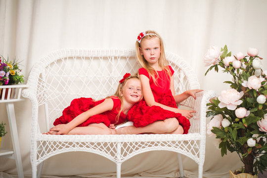 Two little girls sitting in a chair