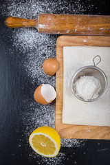 Set for home baking on a black background with flour. Rolling pi