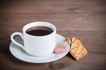 Cup of tea with biscuits and marmalade on old wooden table