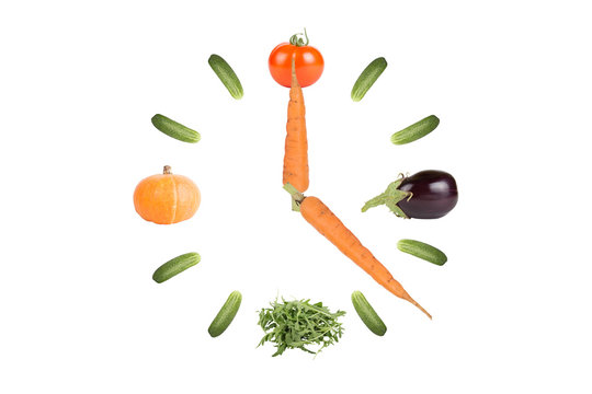 Clock of vegetables with arrows of the carrots Isolated on white
