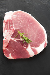 Top view raw pork chop on blackboard