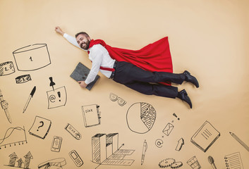 Manager in cloak of superman. Studio shot on a beige background.