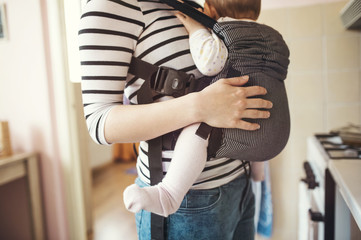 Young mother holding her cute little baby daughter in her arms - obrazy, fototapety, plakaty