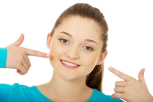 Teenage pointing at toothy smile.