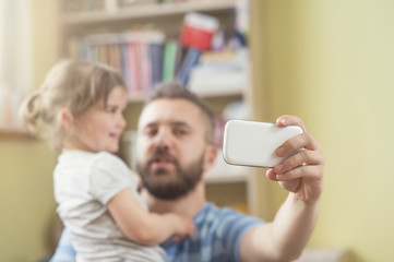 Young father with his cute little daughter taking selfie