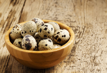 Fototapeta premium Quail eggs on a wooden table, selective focus