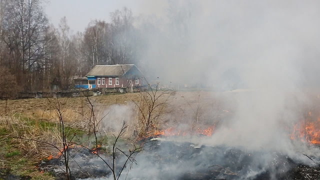 Wildfire in field near house
