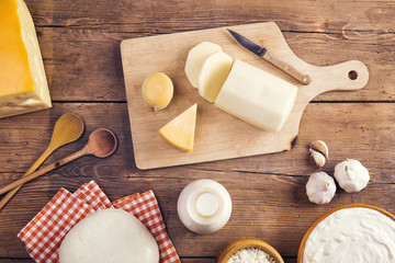 Fototapeta na wymiar Variety of dairy products laid on a wooden table background