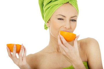 Beautiful woman eating orange.