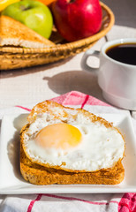 crispy toast with a fried egg and a cup of coffee, fruit, breakf