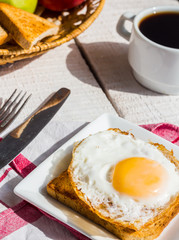 crispy toast with a fried egg and a cup of coffee, fruit, breakf