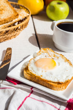 crispy toast with a fried egg and a cup of coffee, fruit, breakf