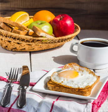 crispy toast with a fried egg and a cup of coffee, fruit, breakf
