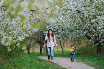 Mother and son walking along the blossoming spring garden