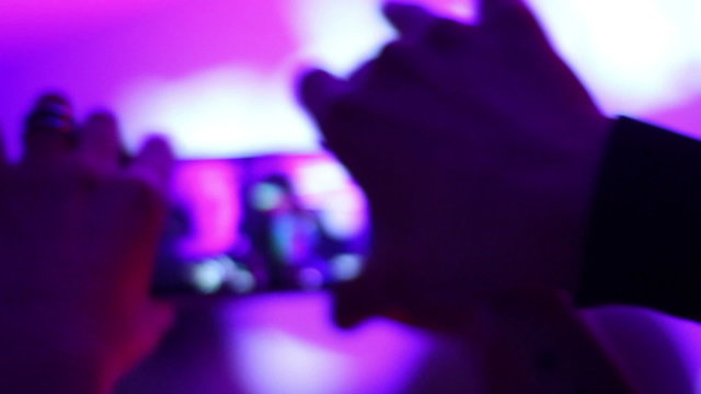 People clubbing, filming DJ performance, touch phone in hands