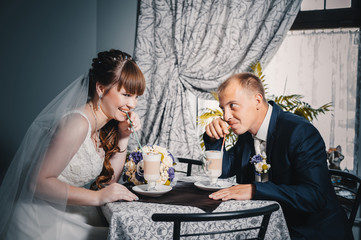 Bride and groom in luxurious restaurant drink a cup of Coffee