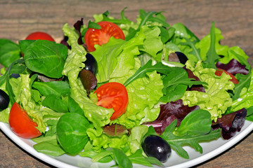 Mixed green salad with tomatoes and olives