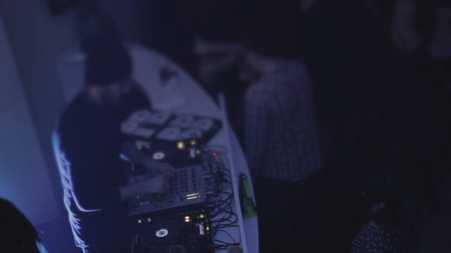 DJ playing tracks, performing, people hanging out, communicating