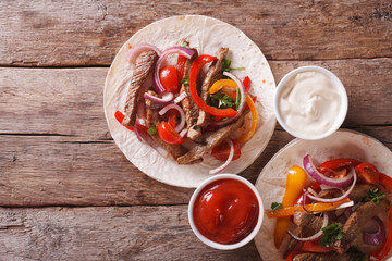 tortillas with meat, vegetables and sauce horizontal top view
