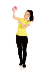 Happy woman shaking piggybank.