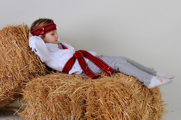 Ukrainian girl in national dress lying on hay