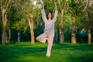Obraz na płótnie Canvas Practicing yoga in the morning, with trees background