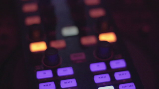 Professional DJ deck, male hands tweak controls, buttons closeup