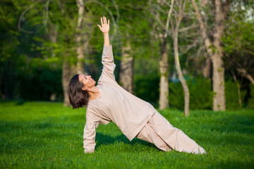 Practicing yoga in the morning, with trees  background