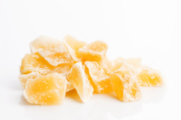 Caramelized ginger candy pieces isolated on white background