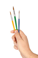 Hand with multicolored paintbrushes