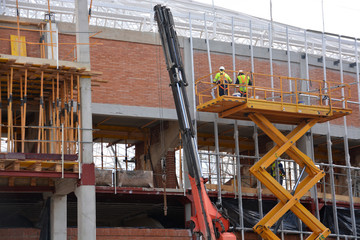 Naklejka premium obreros trabajando sobre una grua