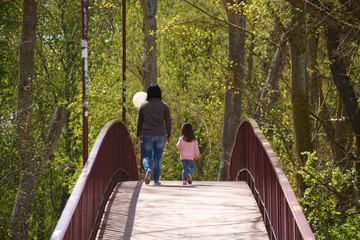 madre e hija atravesando un puente
