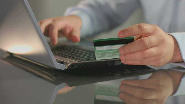 Man paying bill, shopping online, inserting credit card number