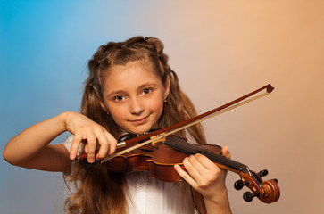 Girl playing the violin isolated on gel background